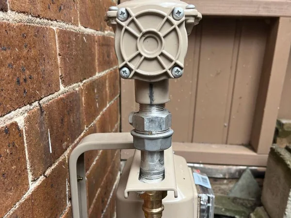 Gas meter and new copper riser on a brick wall