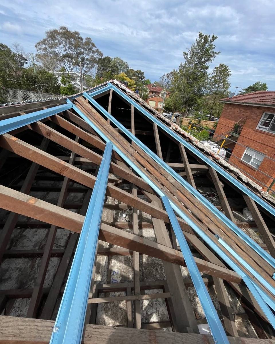 Tile roof removed, timber frame exposed with new metal battens fixed across it