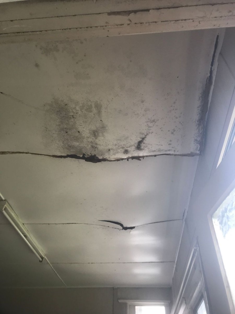 Cracked and water stained ceiling under a leaking roof