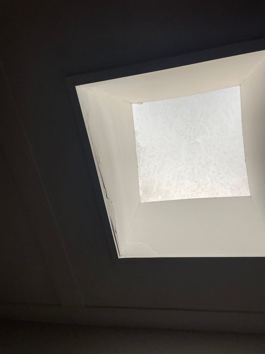 Clean white skylight shaft seen from inside the room