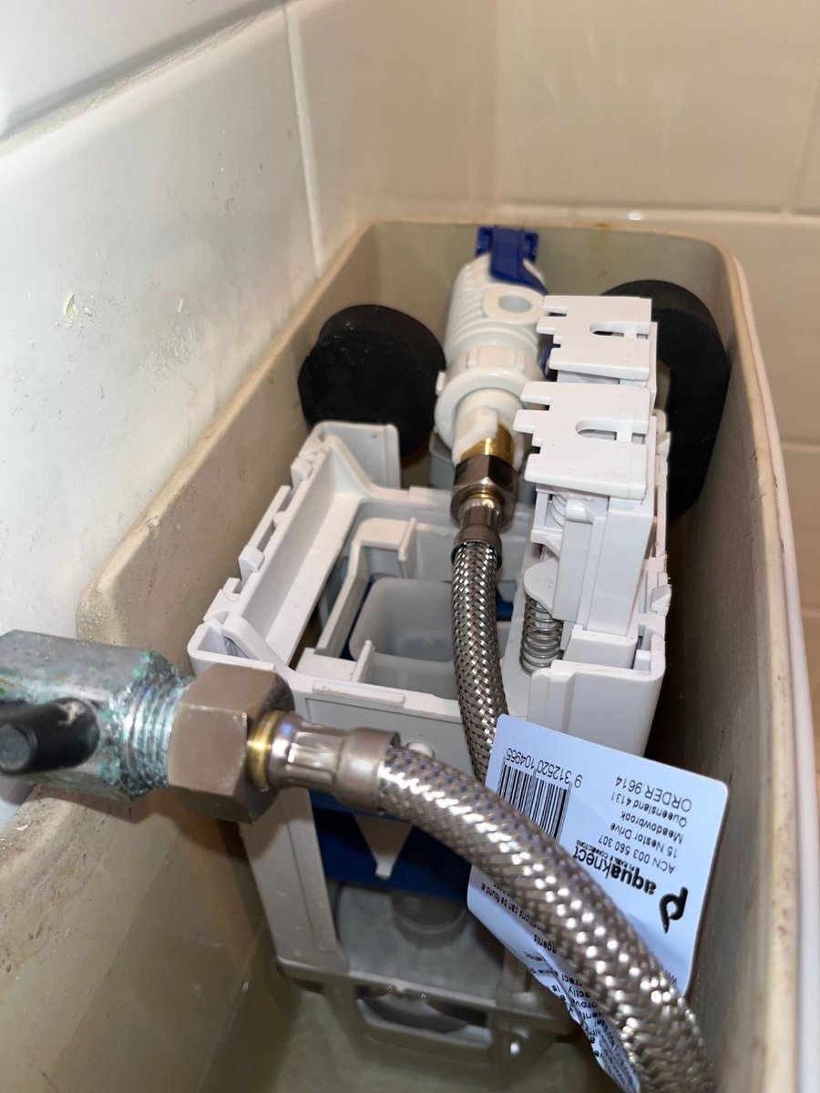 Open toilet cistern with a new inlet valve and connector fitted
