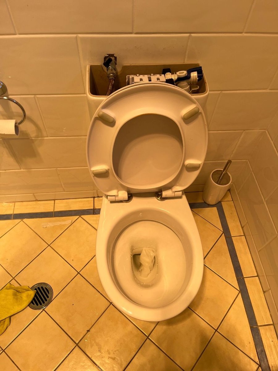 Toilet back in place on a tiled floor, sealed round the base