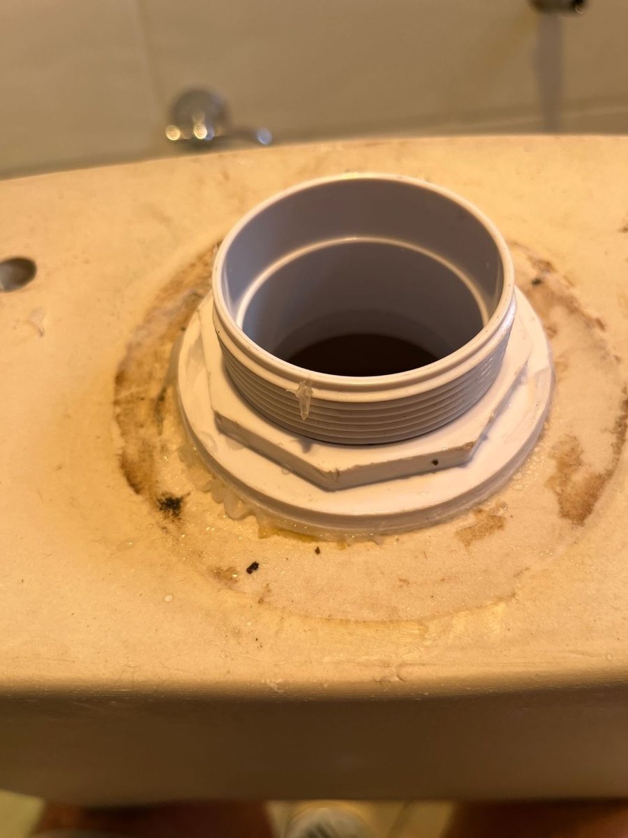 Toilet pan lifted, showing the outlet connector at the floor